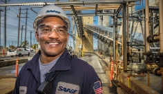 Man smiling in front of industrial facility